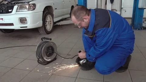 Car mechanic work with circular saw cutting metal with sparks in super slow Stock Footage 74908617