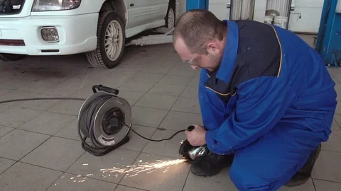Car mechanic work with circular saw cutting metal with sparks in super slow Stock Footage 74909282