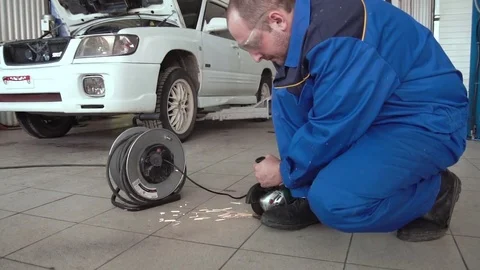 Car mechanic work with circular saw cutting metal with sparks in super slow Stock Footage 74910135