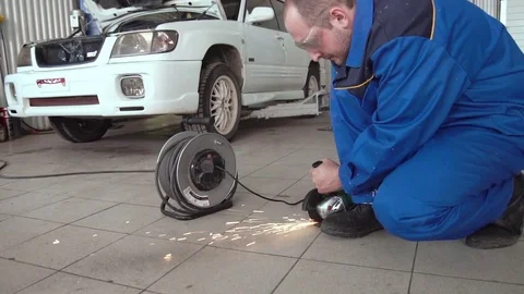 Car mechanic work with circular saw cutting metal with sparks in super slow Stock Footage 74911089
