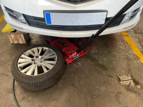 Car in mechanical workshop, wheel replacement. Stock Photos