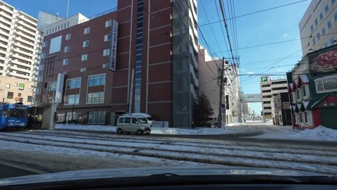 Car merges into main road from side street in Hakodate winter city Video stock 333069381
