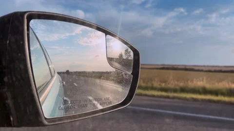 Car mirror with reflection of the road close-up. Traveling by car. Summer travel Stock Footage 307314357