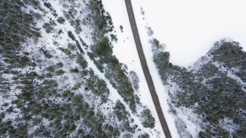 A car moves on the road and drives through the village. Winter. Aerial view Stock Footage 101705677