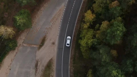 The car is moving along the road through the forest, top view from the throne. C Stock Footage 239849548