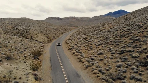 Car moving on asphalt empty desert road. Aerial view flying camera. Stock Footage 100643148