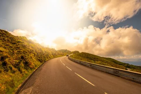 Car moving on a curve road with a sunset over with a Beautiful Nature Landscape. Stock Photos
