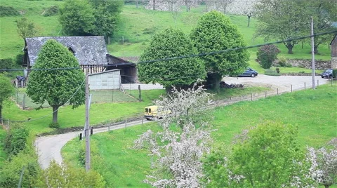 Car moving down the provincial road among green trees and white blossoming cherr Stock Footage 49173003