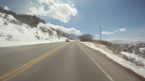 Car moving on road surrounded by snowcapped mountains Stock Footage 55571246