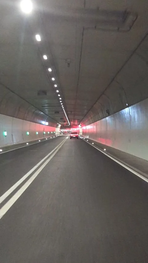Car moving through modern illuminated highway road tunnel vertical 4k POV video. 库存影片 341977507
