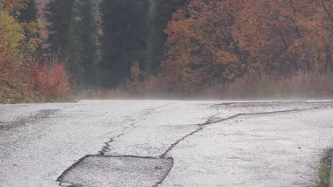 Car navigating a winding road surrounded by autumn foliage and misty atmosphere Video stock 316876307