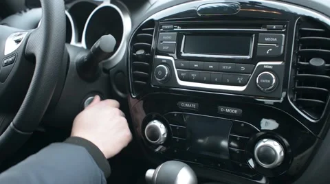 Car Nissan Starting. Male Turning Ignition Key On and push on the Radio Stock Footage 59439940