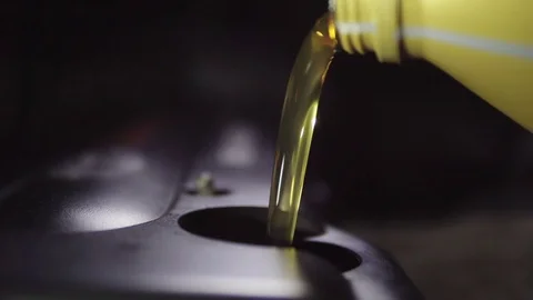 Car oil is poured into the engine. 4k Stock Footage 74484784