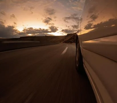 Car on Open Road at Sunset with Dramatic Sky Foto stock