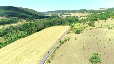 Car Overtaking Cyclists on Road Between Dry Fields - Haute Marne, France 4K Stock Footage 259848212