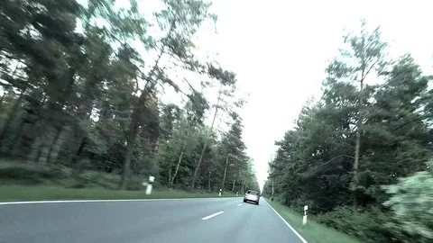 A Car is overtaking on a dangerous road through a forest - POV - Time Lapse Stock Footage 84577041