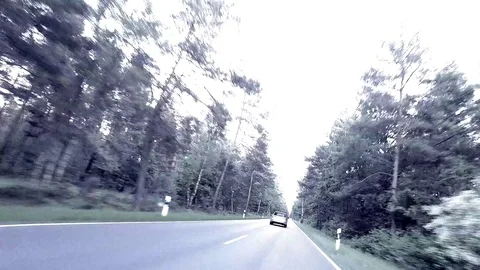 Car is overtaking on a dangerous road through a forest - POV - Time Lapse Stock Footage 84577167