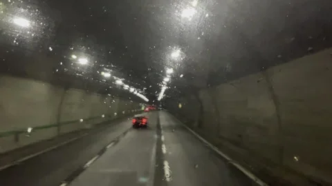 Car overtaking driving truck on multiple lane highway passing through the tunnel Stock Footage 310461747