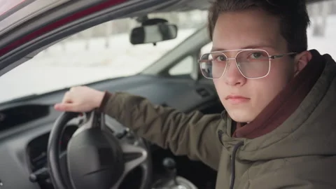 Car owner rolling down window and looking through glass on winter day Stock Footage 310180275