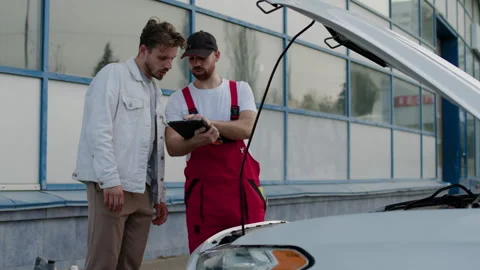 Car owner talks with engineer-mechanic talking about details of vehicle Vidéo 274103274