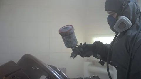 Car painter paint bumper at auto body service, slow motion. Stock Footage 86561294
