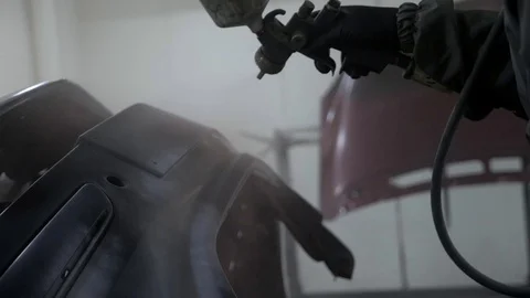 Car painter paint bumper at auto body service, slow motion. Stock Footage 86561310