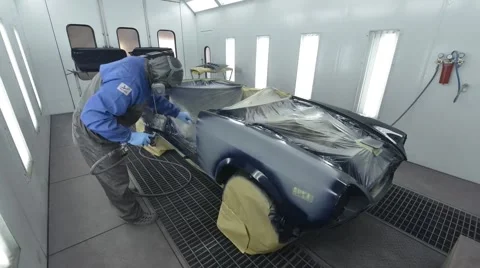 Car painter is painting body work of car in garage box Stock Footage 61166627