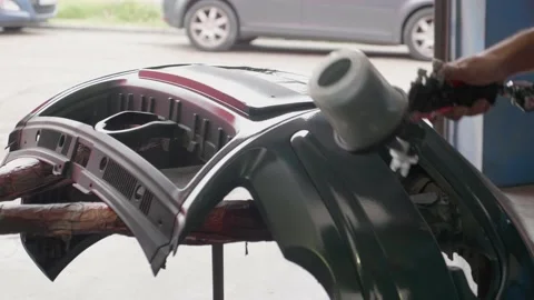 Car painter in workshop giving coat of paint Video stock 148512842