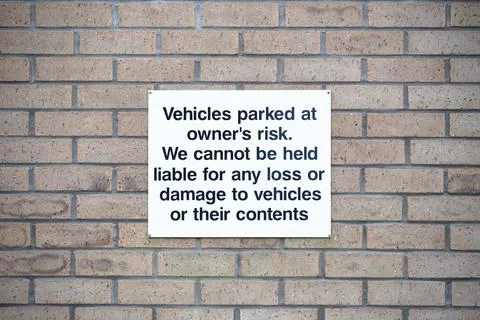 Car park users do so at own risk sign Stock Photos