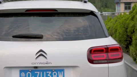 Car parked on the side of the road behind the grass Stock Footage 157623730