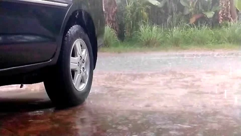 A car parked on the side of the road got wet in the rain Stock Footage 243345275