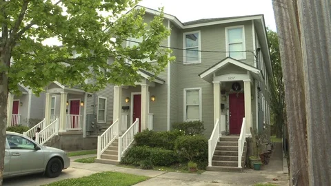 Car parked under a tree outside apartments 動画素材 84512897