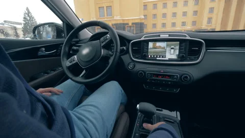 A car parking on autopilot while a man sits in it, close up. Stock Footage 100564059