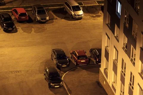 Car parking at night in a dark yard at residental aeria in a corner of a buil Fotos de archivo