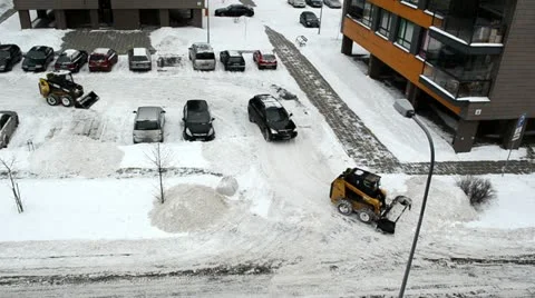 Car pass between tractor clean flat house parking lot winter Stock Footage 14775831