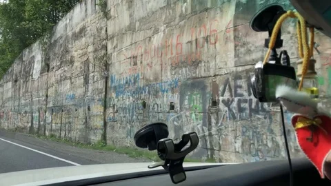 The car passes a large painted stone wall Stock Footage 124791623