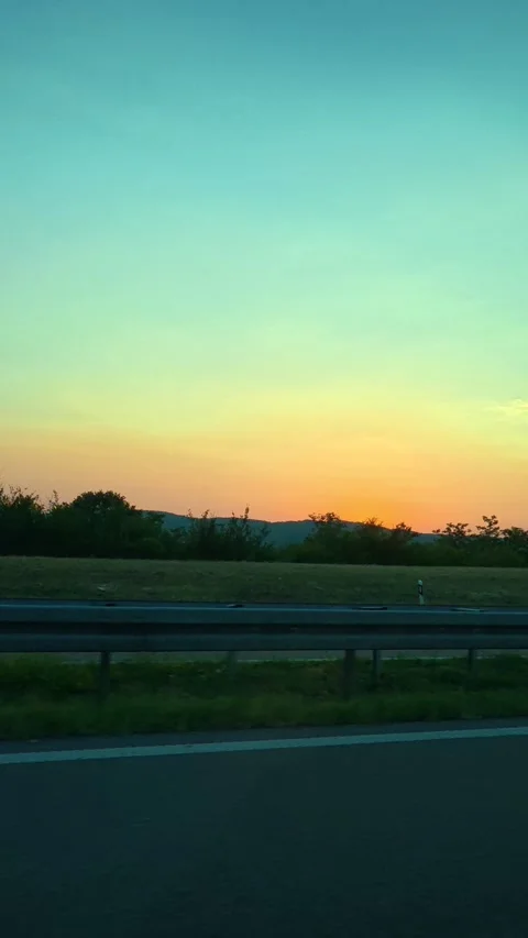 Car passes quietly, framed by guardrail. Vertical Vídeo Stock 341968205