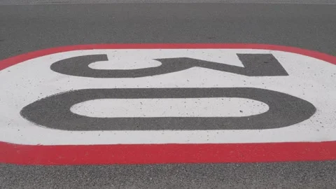 Car passing a 30 km h horizontal speed limit sign painted on an asphalt road. Stock Footage 157416586