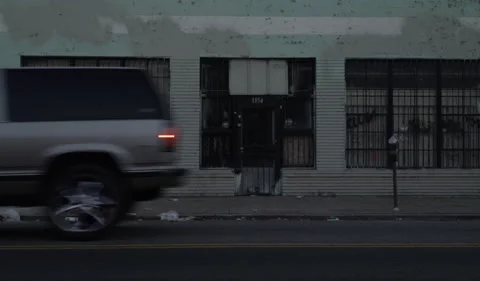 Car passing in front of abandon store front Stock Footage 138905445