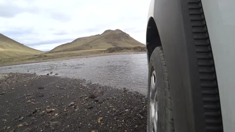 Car passing the river in Iceland. Camera near the wheel level Vídeo Stock 149106709