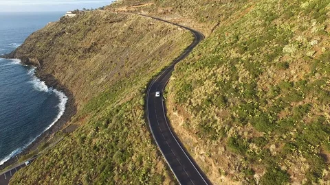 Car passing on road through mountain near the ocean - Tenerife 動画素材 88287817