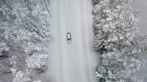 Car Passing on Snowy Road Between Snow Covered Trees, Low Aerial Top Down View Stock-Footage 149705533