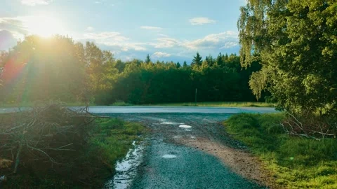 Car passing wet rural intersection. Gray hatchback driving across reflective Stock Footage 319989946