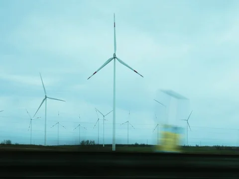 Car passing by windmill farm with wind turbines. Stock Footage 79987627