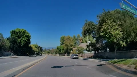 Car point of view of a suburban road past green hillsides, Los Angeles #6 Stock Footage 343476078