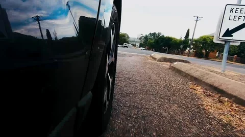 Car POV from road facing front right wheel driving down bitumen road down Stock Footage 101722998