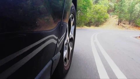 Car POV from road facing front right wheel driving down bitumen road down Stock Footage 101723003