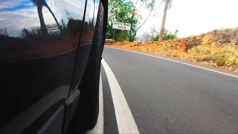 Car POV from road facing front right wheel driving down bitumen road down Stock Footage 101723012
