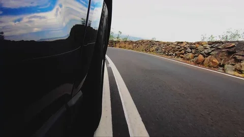 Car POV from road facing front right wheel driving down bitumen road down Stock Footage 101723025