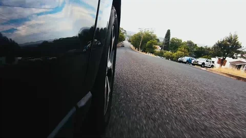 Car POV from road facing front right wheel driving down bitumen road down Stock Footage 101723030